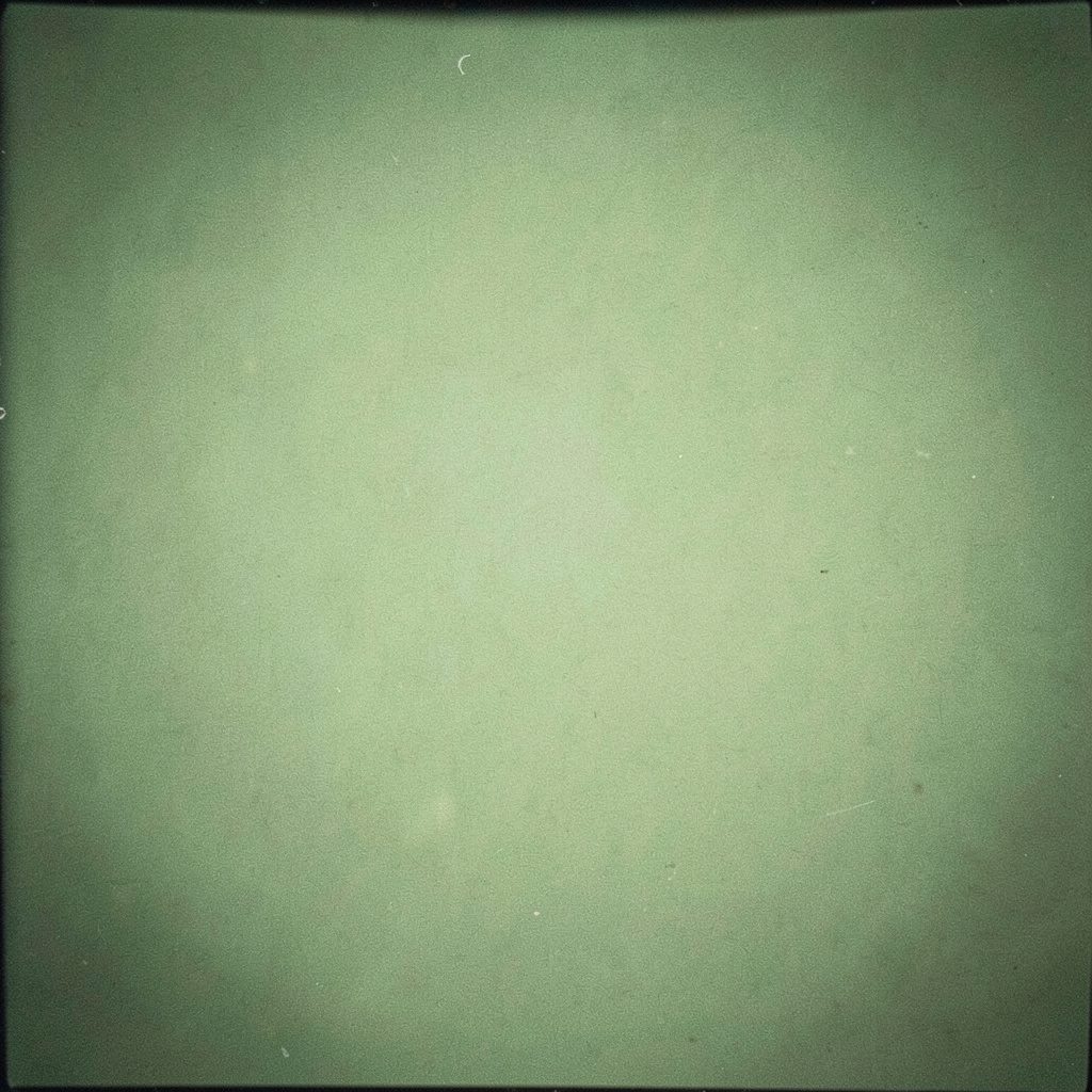 Analog film photograph of a mixing desk lit by warm green and amber light, grainy texture, moody studio atmosphere