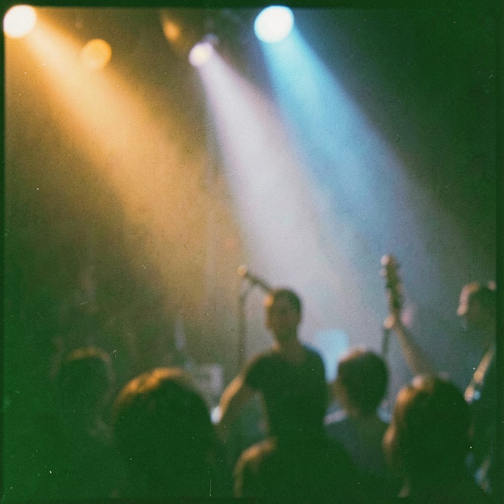 Analog film photograph of warm stage lighting in amber and blue tones, atmospheric and softly out of focus, visible film grain